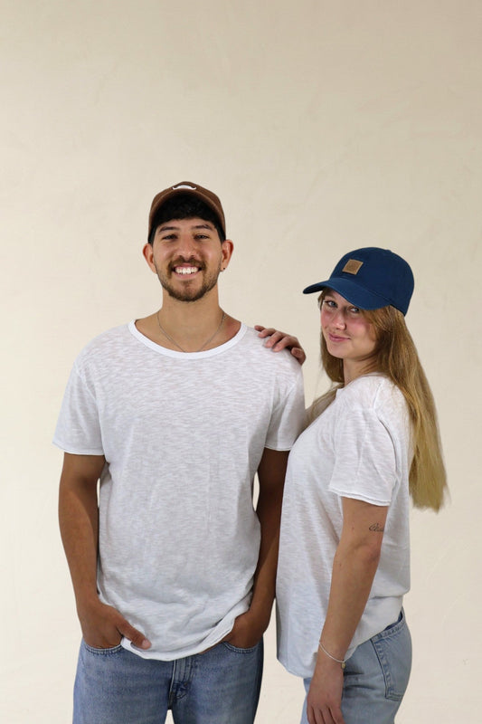 Two people wearing white t-shirts and casual clothing against a plain background