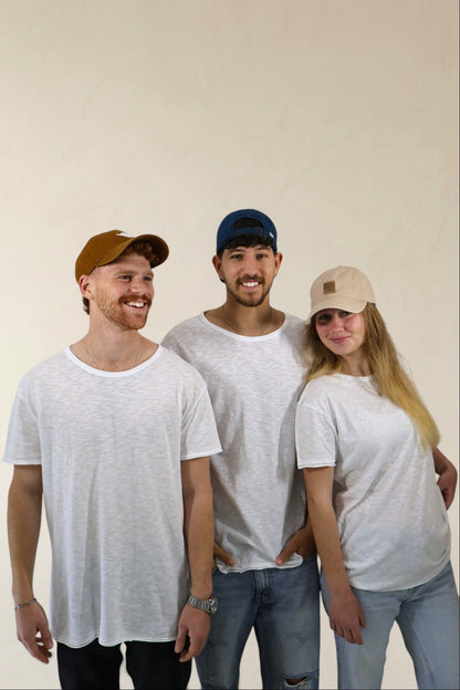 Three people wearing white t-shirts and casual clothing against a plain background
