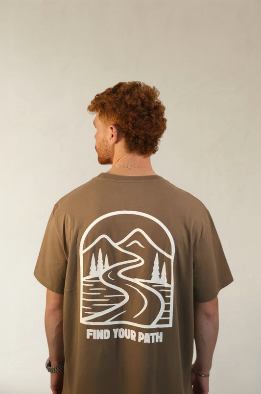 Man wearing a brown t-shirt with a mountain and road graphic on the back, text 'Find Your Path', against a plain background.